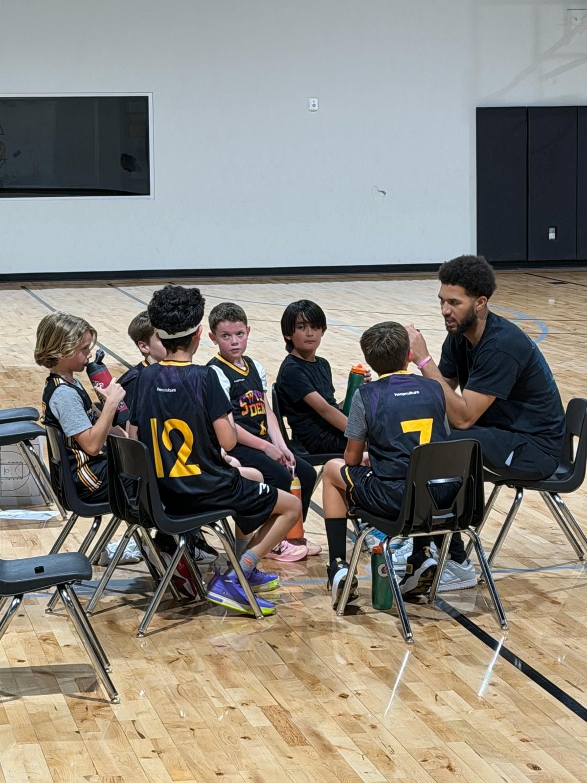 A Swysh Forward Foundation coach talking with a group of young players